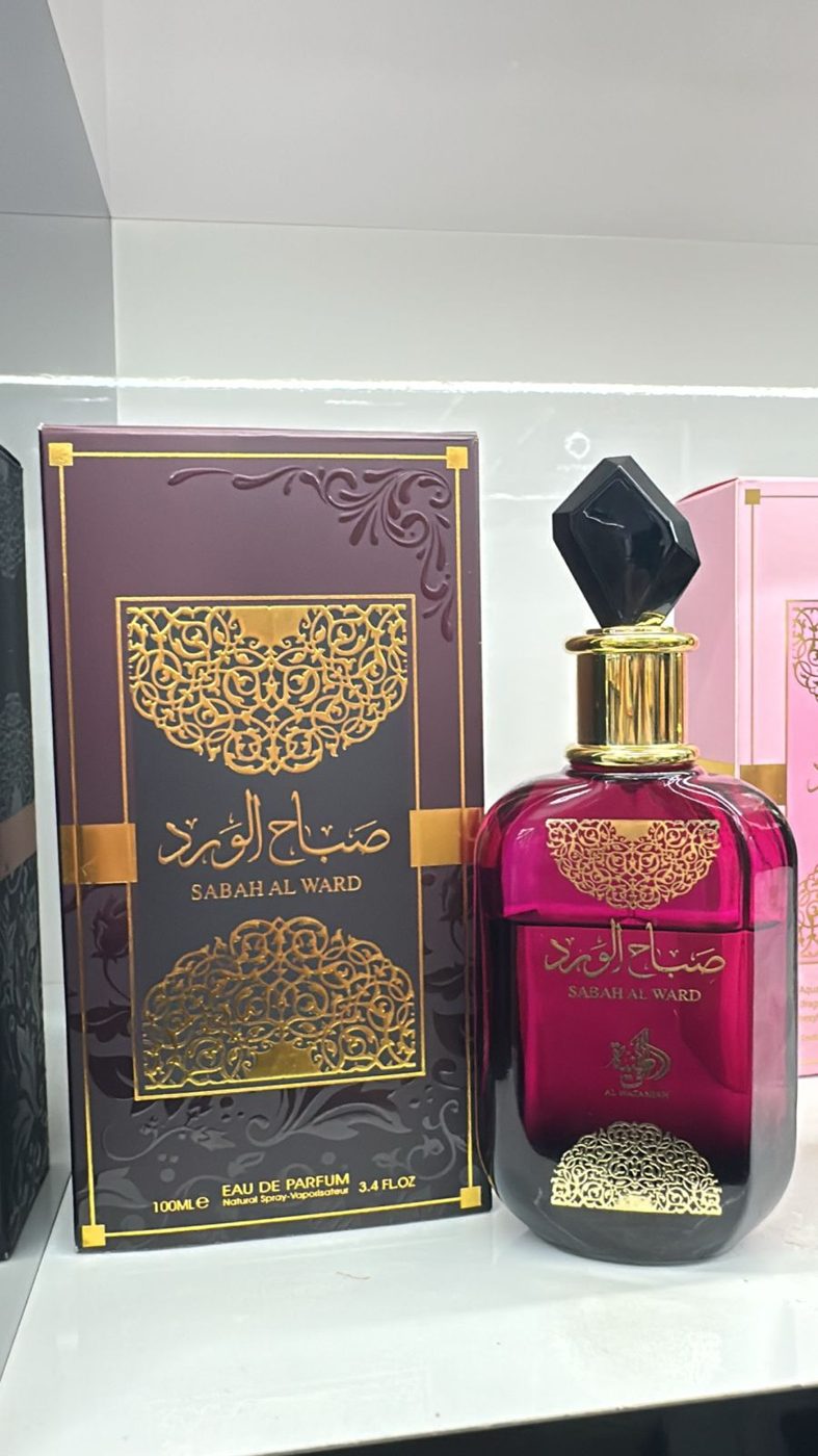 Perfume árabe em frasco dourado minimalista ao lado da caixa vinho