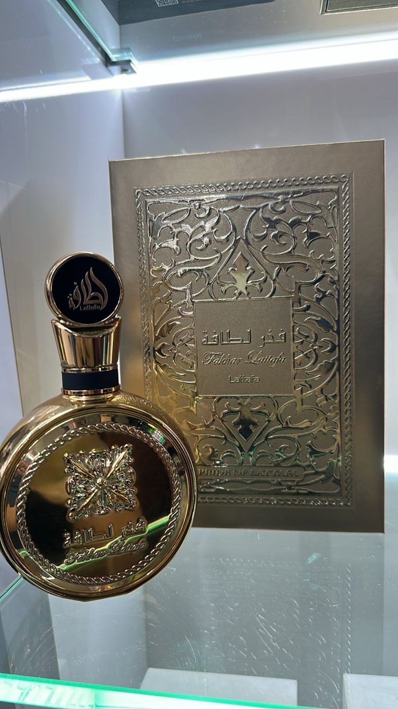 Perfume árabe em frasco escuro com medalhão prateado sobre a bancada da loja