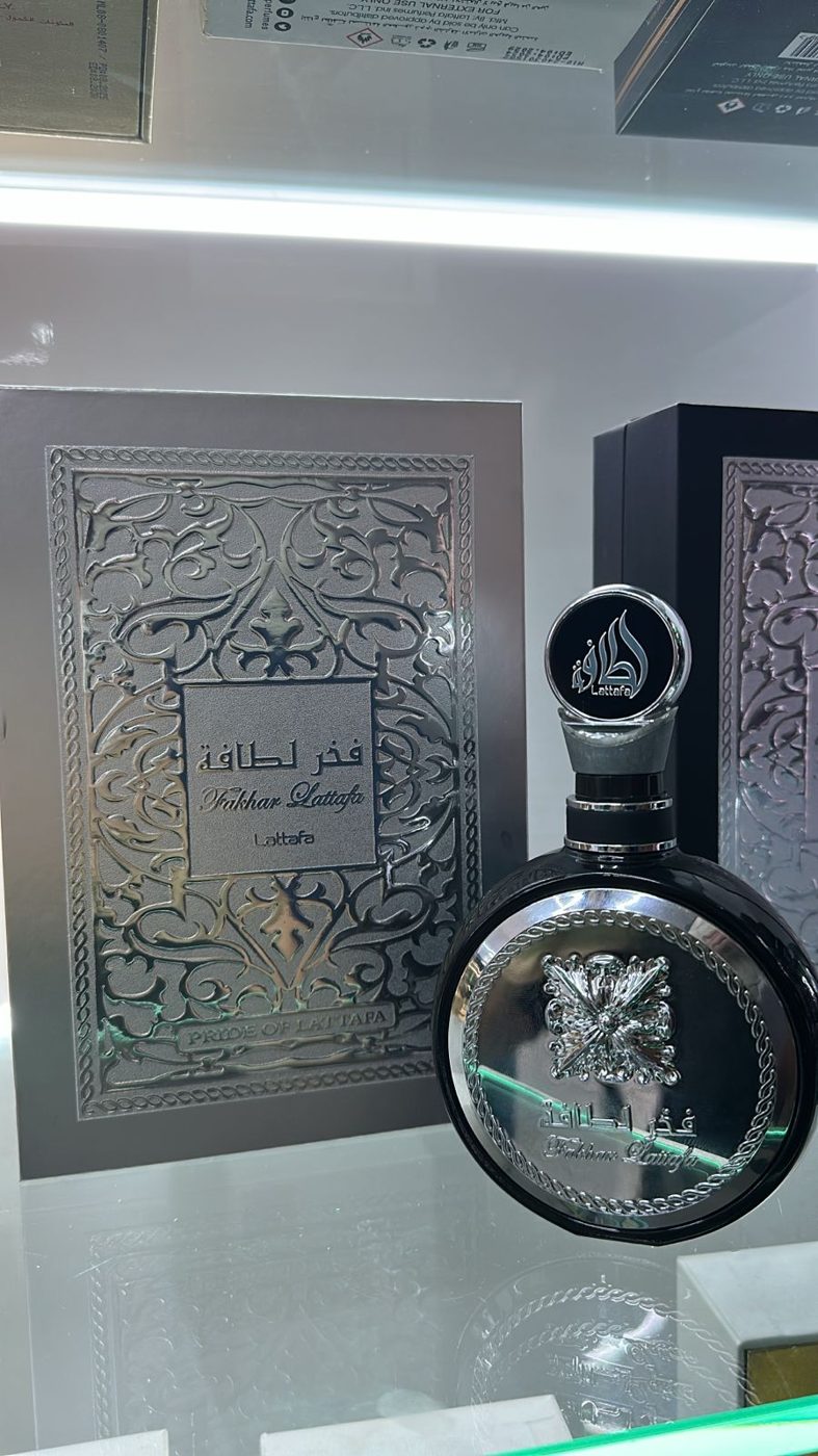 Perfume árabe em frasco prateado com medalhão e arte ao fundo